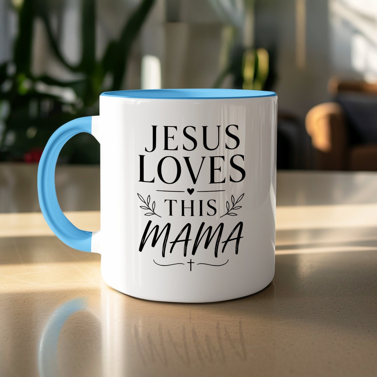White mug with blue handle, reading "JESUS LOVES THIS MAMA" with a cross.